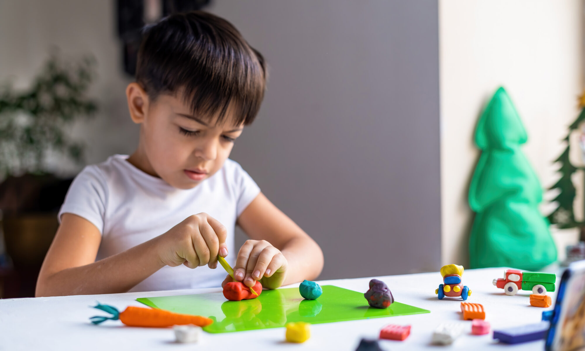 Small Caucasian Boy Playing With Colored Plasticine Making Figures White Table Happy Child Idea | Play and Dream Toys UAE
