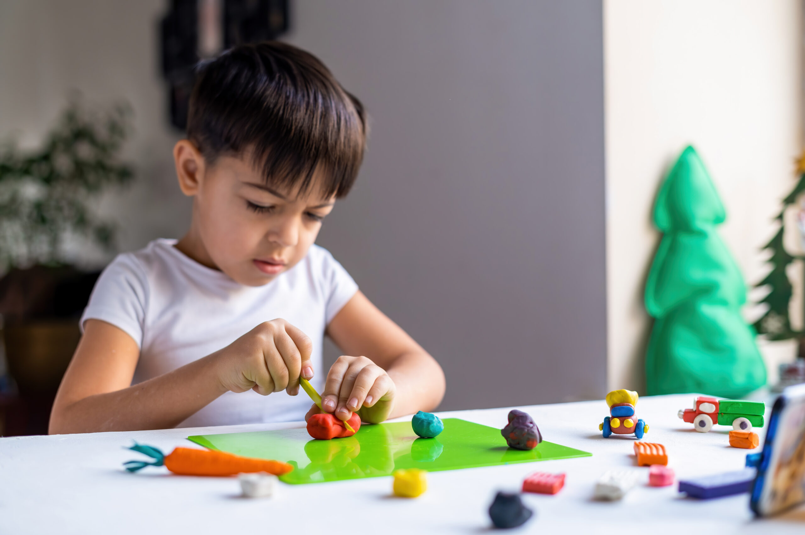Small Caucasian Boy Playing With Colored Plasticine Making Figures White Table Happy Child Idea | Play and Dream Toys UAE